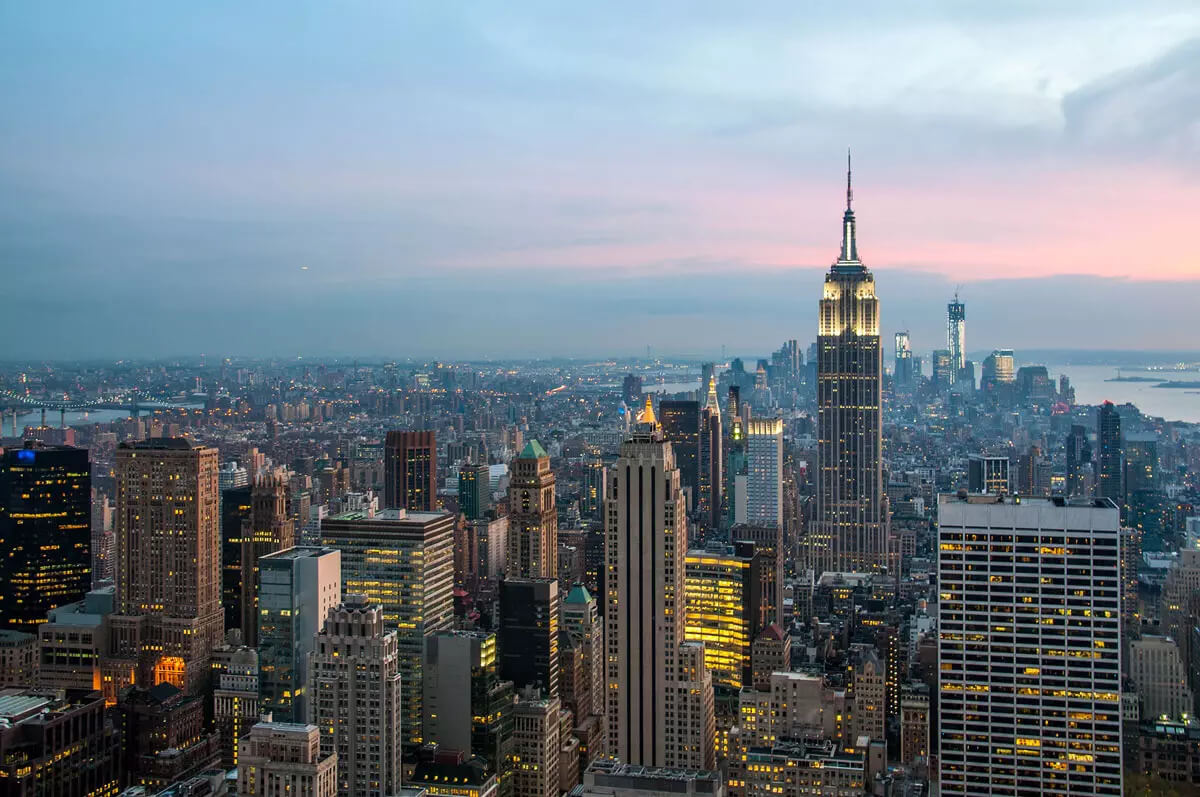 View of a city with lots of buildings at sunset.